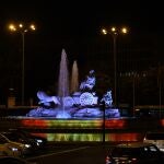 La fuente de Cibeles iluminada con la bandera de España