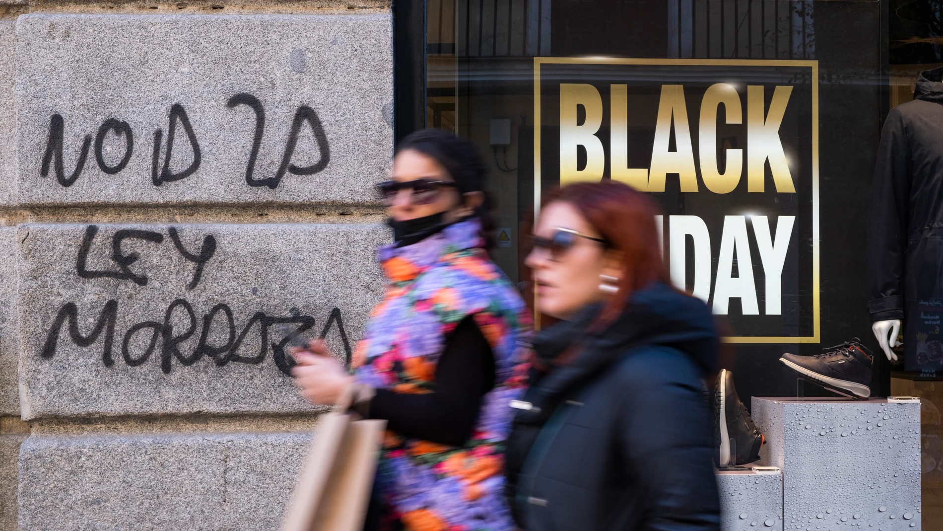 Imagen de tiendas en Black Friday. Pintada de "No a la Ley Mordaza".
