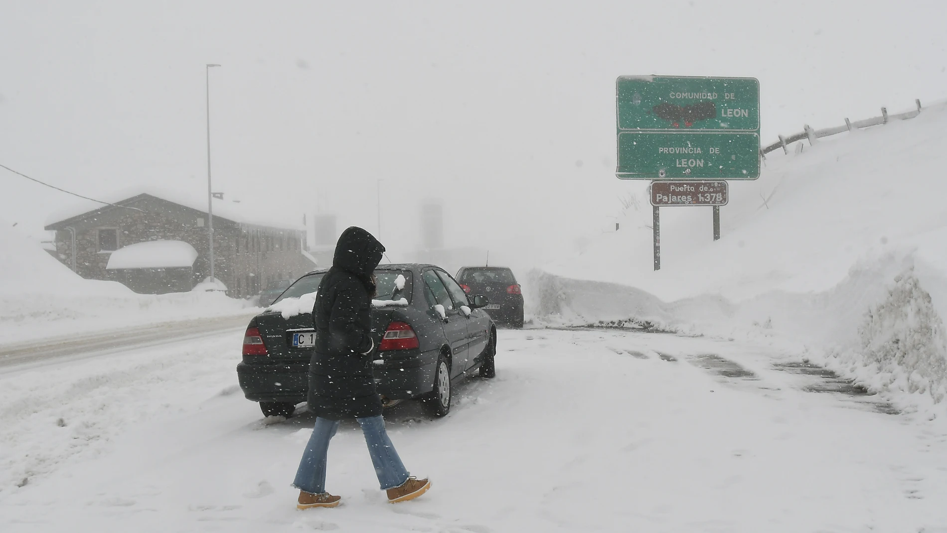 Una persona camina por el puerto de Pajares, totalmente nevado.