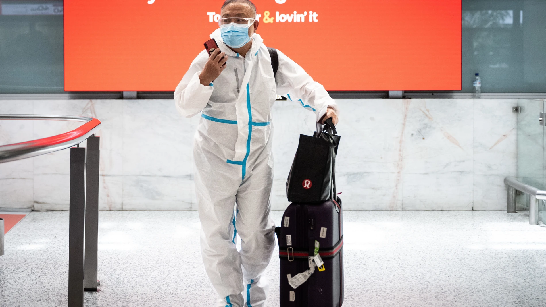 Sydney (Australia), 29/11/2021.- A traveler wearing personal protective equipment (PPE) arrives at Sydney International Airport in Sydney, New South Wales (NSW), Australia, 29 November 2021. The Omicron variant of SARS-CoV-2, the virus that causes COVID-19, has arrived in Australia after testing confirmed two overseas travellers who arrived in Sydney were infected with the new strain. EFE/EPA/JAMES GOURLEY AUSTRALIA AND NEW ZEALAND OUT