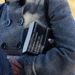 Una mujer con un libro en la mano durante el entierro de la escritora Almudena Grandes, en el Cementerio de la Almudena el pasado 29 de noviembre