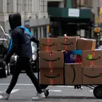 An Amazon delivery worker pulls a cart full of boxes for delivery on Cyber-Monday in New York City, U.S., November 29, 2021. REUTERS/Brendan McDermid REFILE - CORRECTING DATE