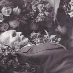 Post-mortem de un anciano sosteniendo un rosario.
