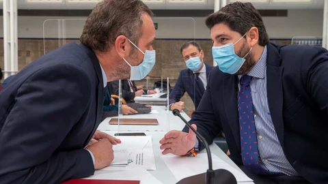 El presidente de Murcia, Fernando López Miras (d), conversa con el portavoz del PP Joaquín Segado (i), momentos antes del inicio del pleno en la Asamblea Regional