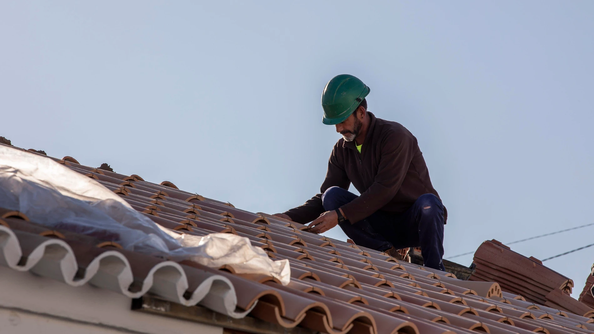 Un obrero realiza su labor en el tejado de una vivienda, en foto de archivo. AYTO.HUELVA