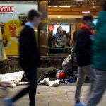 Imagen de una persona sin hogar durmiendo en la puerta de un McDonald's en Gran Vía.