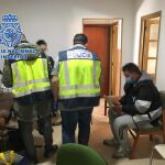 Efectivos de la Policía Nacional con uno de los detenidos