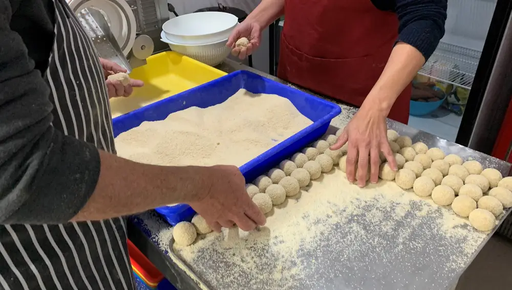 Dos trabajadores de la empresa ‘La croqueta coqueta’ de Castilleja de la Cuesta (Sevilla) preparan croquetas con una base de mantecado de Estepa. EFE/Fermín Cabanillas