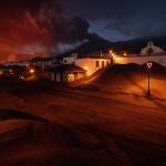 Ash covers the streets and houses in Las Manchas village as lava flows from the volcano, on the Canary island of La Palma, Spain, Monday, Dec. 6 2021. (AP Photo/Emilio Morenatti)