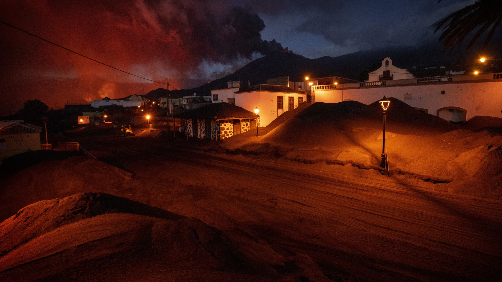 Ash covers the streets and houses in Las Manchas village as lava flows from the volcano, on the Canary island of La Palma, Spain, Monday, Dec. 6 2021. (AP Photo/Emilio Morenatti)