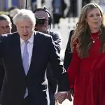 Johnson saluda a los medios mientras camina junto a su esposa Carrie antes de dar su discurso de apertura en la conferencia del Partido Conservador en Manchester