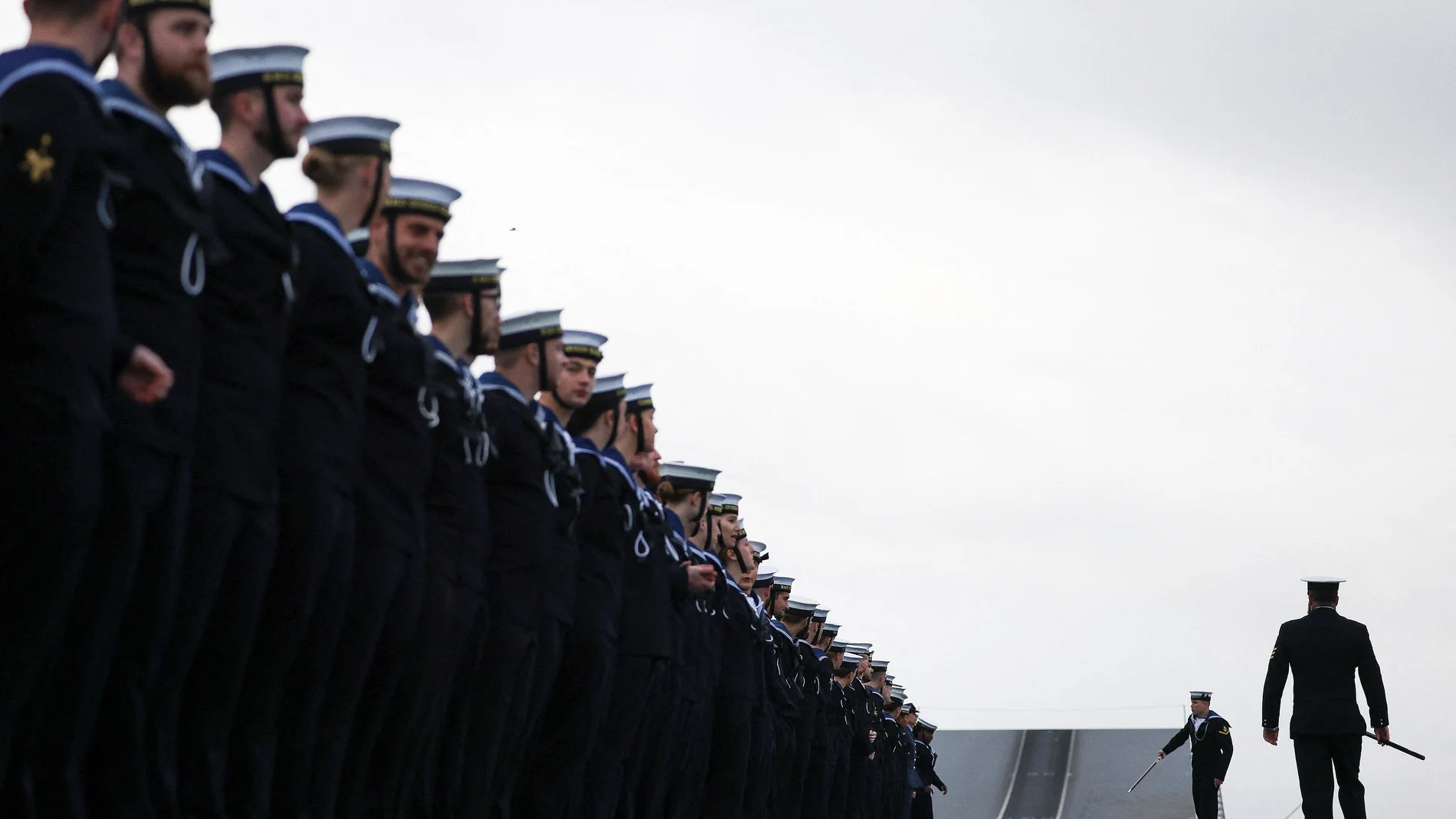 Miembros de la Marina Real británica se preparan en la cubierta de vuelo del portaaviones HMS Queen Elizabeth en Portsmouth, Reino Unido