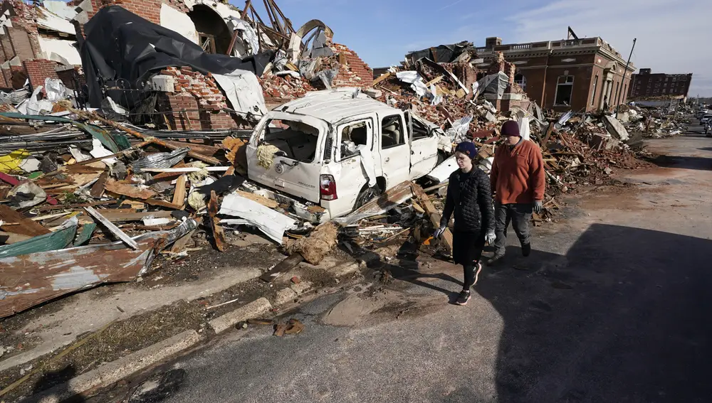 People survey damage from a tornado is seen in Mayfield, Ky., on Saturday, Dec. 11, 2021. Tornadoes and severe weather caused catastrophic damage across multiple states late Friday, killing several people overnight. (AP Photo/STF