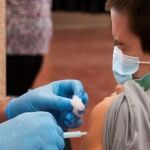 En la imagen, un niño es vacunado con su primera dosis