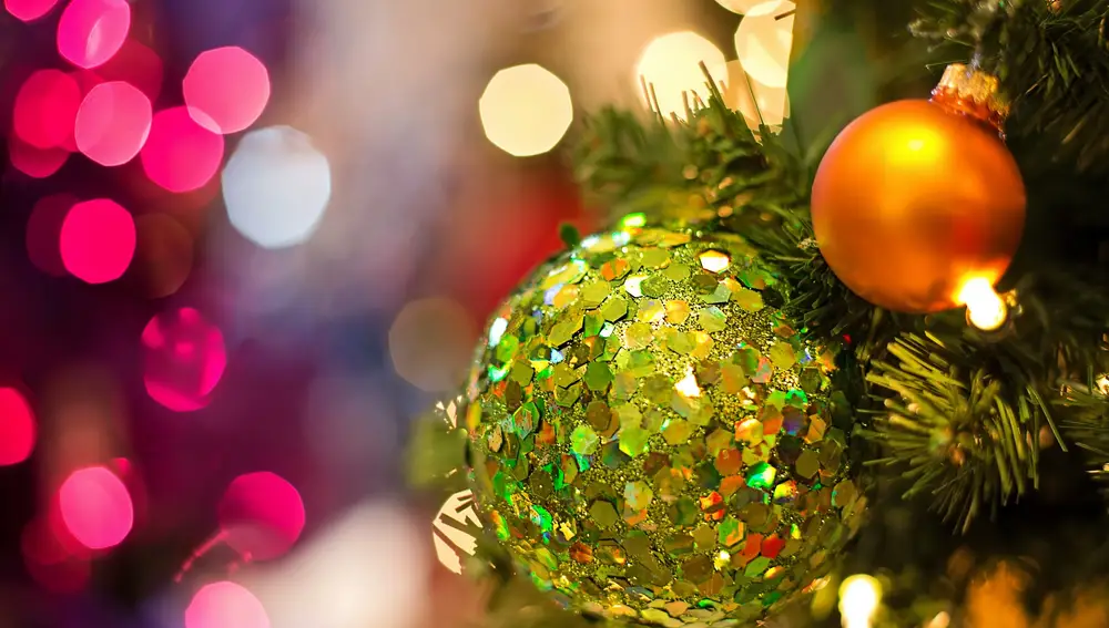 Imagen detalle de bolas y luces de navidad de un árbol instalado en la vía pública