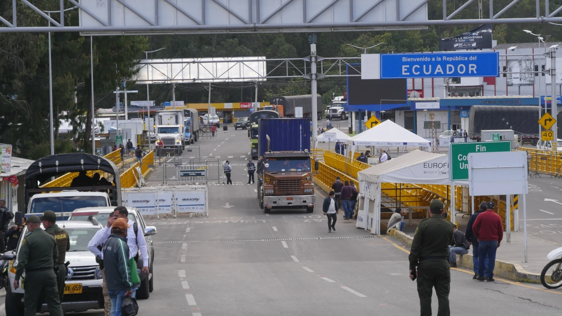 AME4627. TULCÁN (ECUADOR), 15/12/2021.- Camiones cruzan la frontera de Ecuador y Colombia tras su reapertura hoy, miércoles en Tulcán (Ecuador). Las dos naciones reabrieron este miércoles su frontera terrestre al paso, hasta 11 kilómetros, de conductores de camiones de carga pesada, en una medida para aliviar el transporte de mercancías entre los dos países. Así lo refrendaron ambos Gobiernos en un protocolo que sus respectivos ministros de Transporte, Marcelo Cabrera y Ángela María Orozco, firmaron en la sede del ECU911.EFE/ Xavier Montalvo