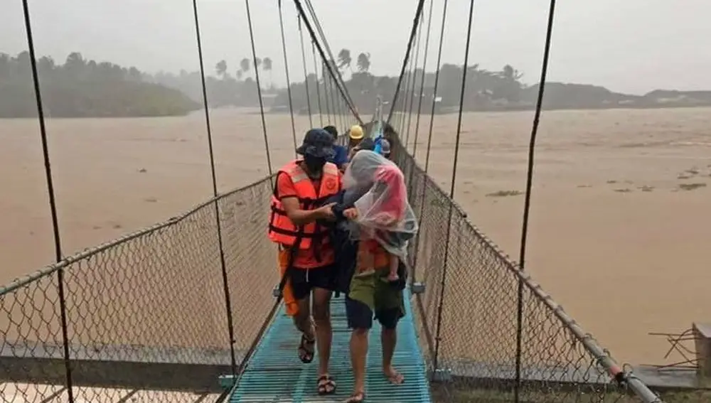 Personal evacúa a los residentes afectados por las inundaciones en la ciudad de Tubay, en el sur de Filipinas, afectada por el tifón Rai