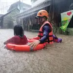 Un guardia costero asiste a una niña en la ciudad filipina de Cagayan De Oro tras la llegada del tifón Rai