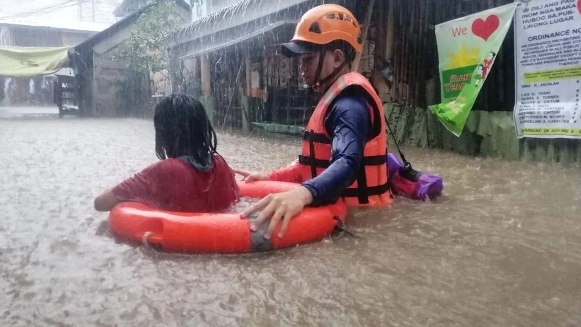 Un guardia costero asiste a una niña en la ciudad filipina de Cagayan De Oro tras la llegada del tifón Rai
