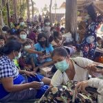 Myanmar villagers rest in an evacuation area after fleeing to Thailand following clashes between Myanmar troops and an ethnic Karen rebel group Friday, Dec. 17, 2021, in Mae Tao, Tak province, northern Thailand. Fighting between Myanmar government forces and ethnic guerrillas has sent about 2,500 villagers fleeing across the border into Thailand, a Thai army officer said Friday. (AP Photo/Chiraunth Rungjamratratsami)