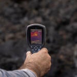 Un hombre mide la temperatura de una colada de lava, en la zona de exclusión próxima al volcán de Cumbre Vieja, a 17 de diciembre de 2021, en La Palma, Canarias (España).