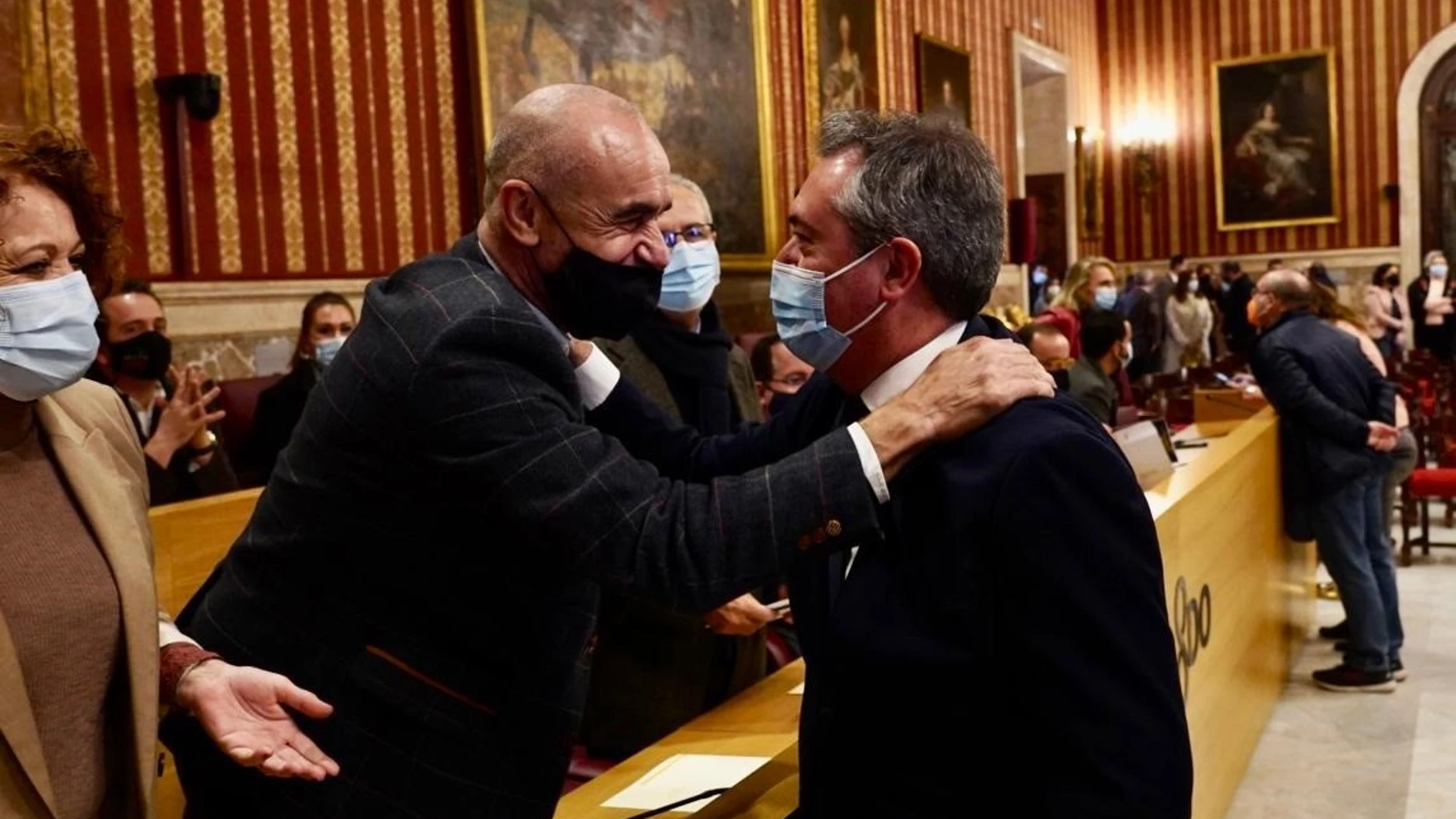 Juan Espadas saluda a Antonio Muñoz minutos antes de leer su renuncia al cargo en el Pleno extraordinario del Ayuntamiento de Sevilla. EDUARDO BRIONES/EP