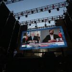 En pantallas gigantes se observa el saludo del presidente Piñera (i) al presidente electo Gabriel Boric (d), en Santiago (Chile).