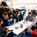 Un camarero pide certificado a los clientes en una mesa en la terraza de un bar en Málaga