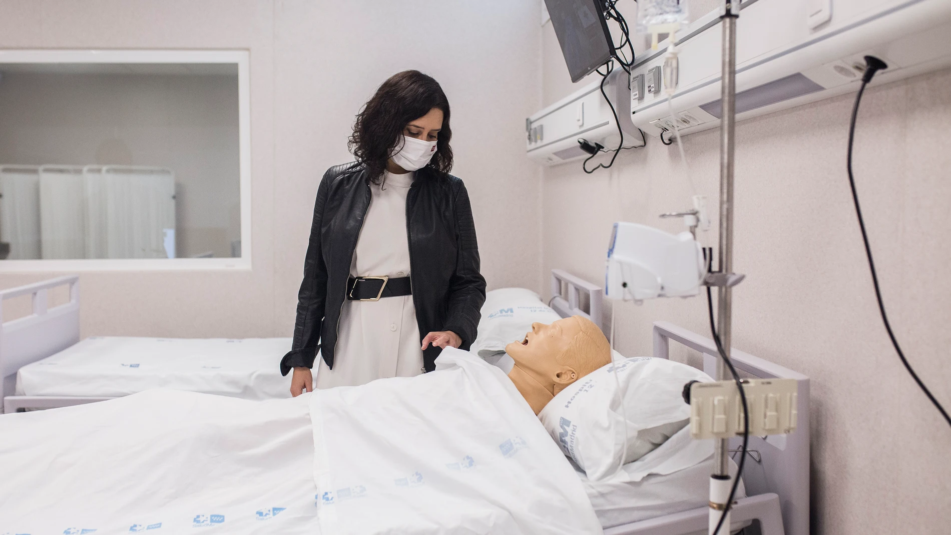 La presidenta de la Comunidad de Madrid, Isabel Díaz Ayuso, observa un maniquí que simula a un paciente durante su visita al Complejo Hospitalario 12 de Octubre