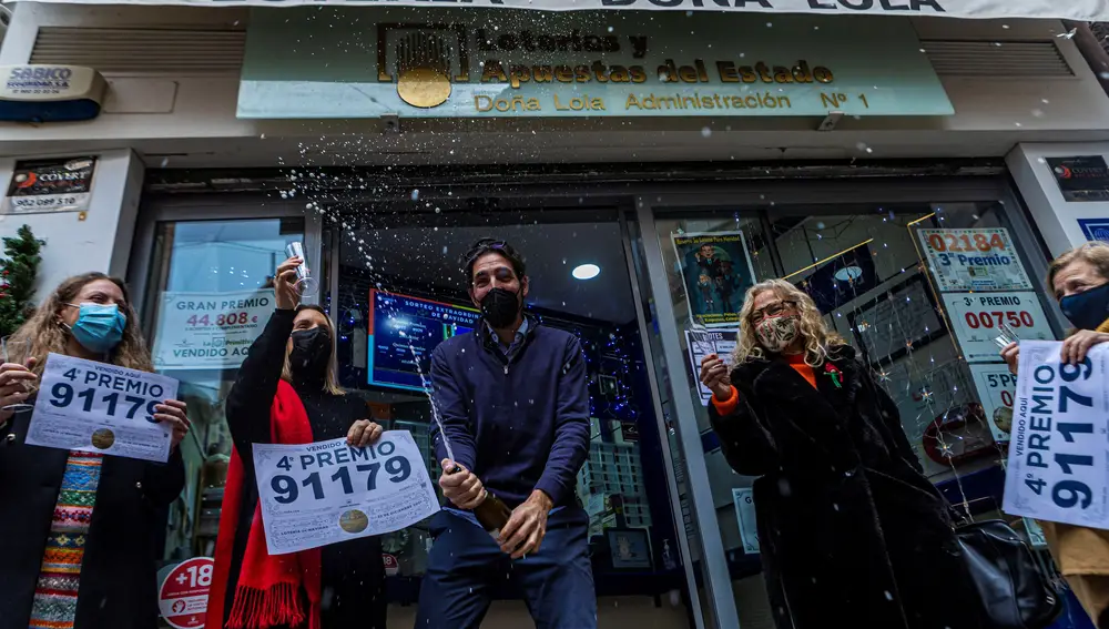 Trabajadores de la administración de lotería Doña Lola en Toledo celebran la venta del número 91179 agraciado con el cuarto premio de la lotería de navidad