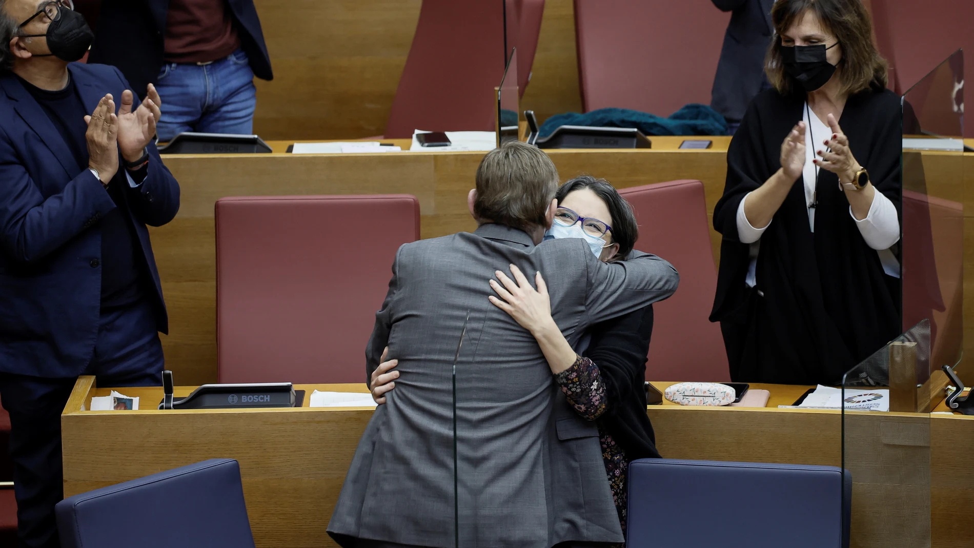 El presidente de la Generalitat, Ximo Puig, abraza a la vicepresidenta del Consell, Mónica Oltra, durante el pleno de Les Corts Valencianes que ha aprobado los Presupuestos de la Generalitat para 2022