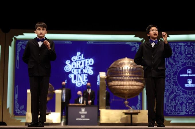 Dos de los niños de la residencia de San Ildefonso sostienen la bola con la que han cantado uno de los quintos premios del Sorteo Extraordinario de la Lotería de Navidad 2021 | Eduardo Parra / Europa Press