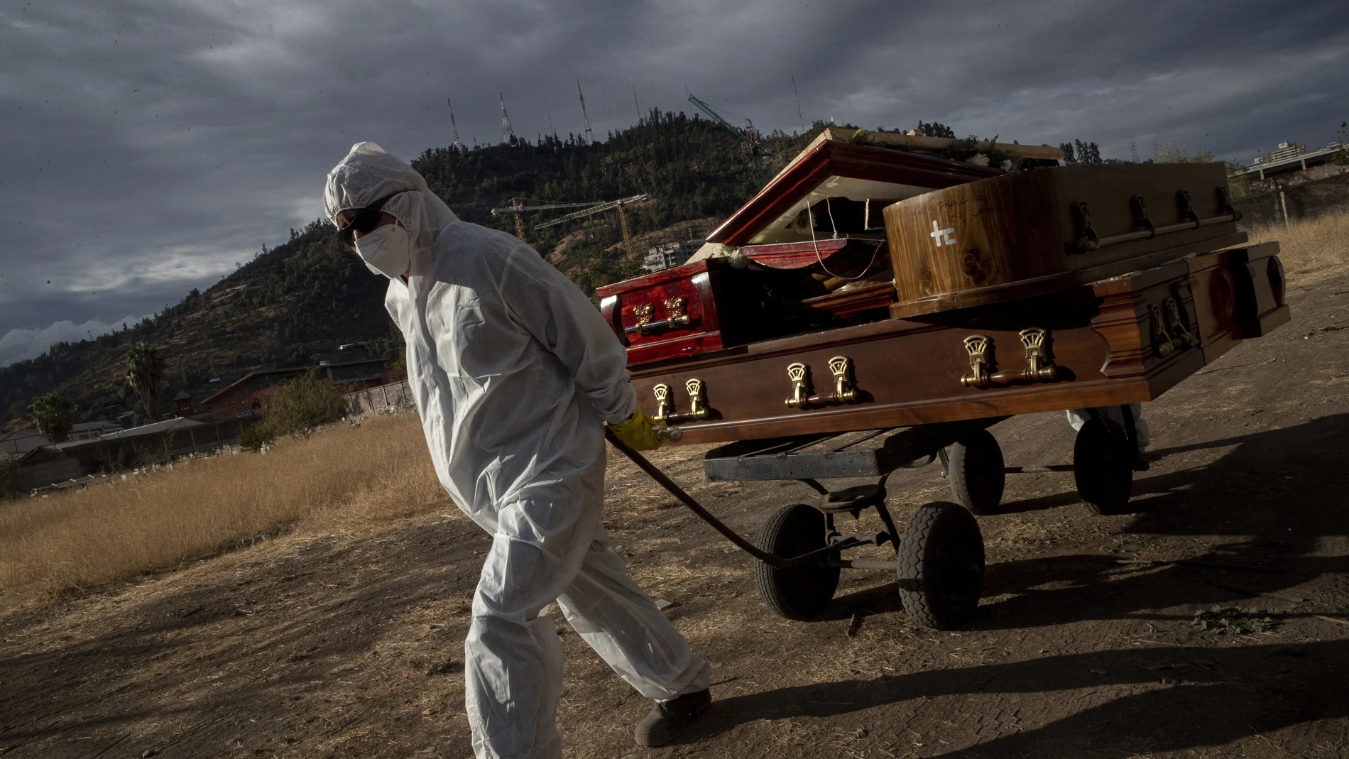 A funeral worker removes empty coffins that held remains that were later cremated at La Recoleta cemetery in Santiago, Chile, during the coronavirus pandemic, on April 21, 2021. (AP Photo/Esteban Felix)