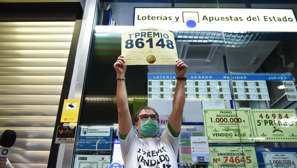 Javier Moñino, empleado de la administración situada en la zona del AVE de la Estación de Atocha, celebra que ha vendido parte del número 86148 correspondiente al 'Gordo' del Sorteo Extraordinario de la Lotería de Navidad,