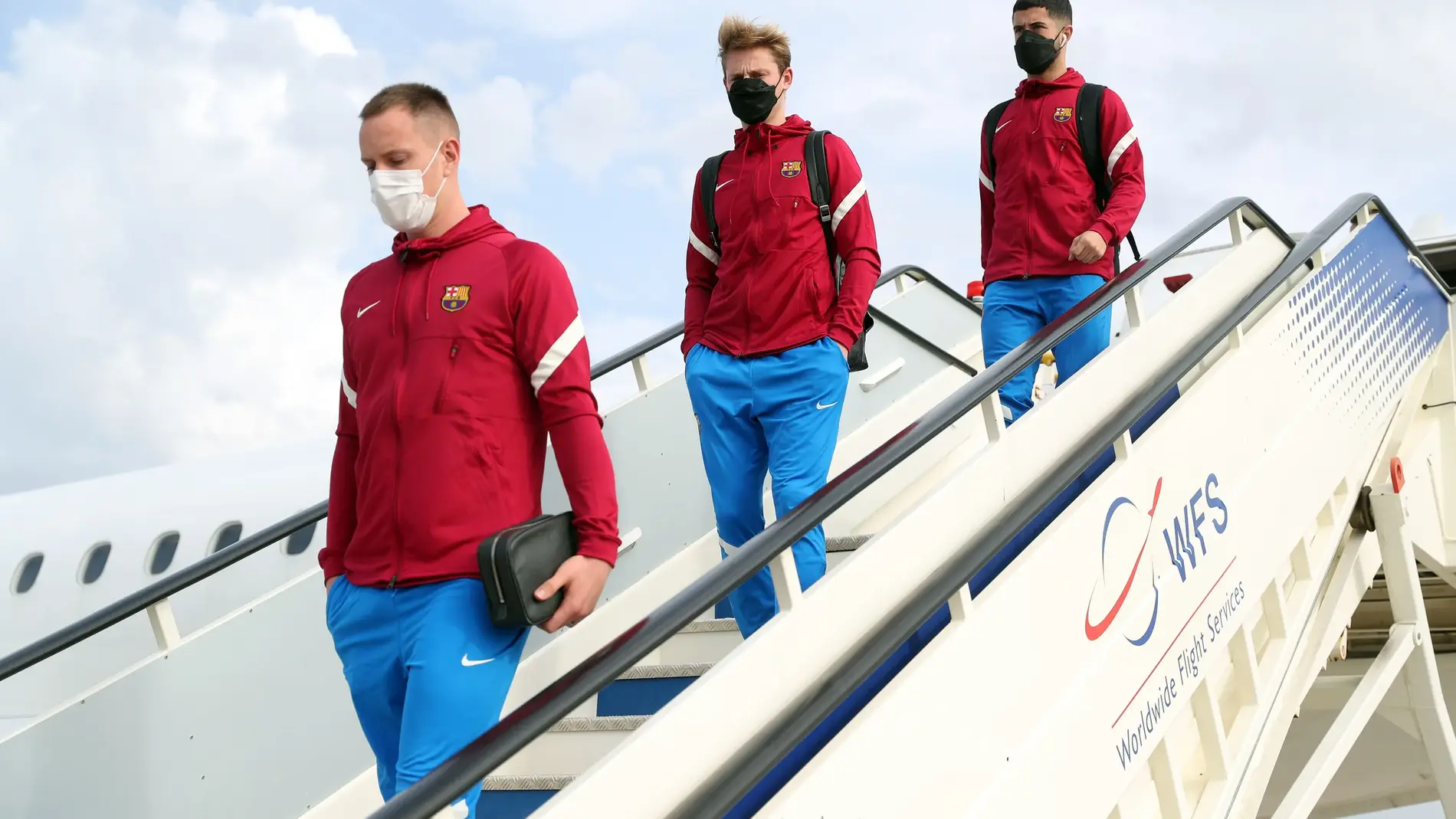 Los futbolistas del Barcelona, con mascarilla, bajan del avión en Sevilla