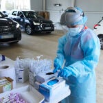 Una sanitaria se cambia los guantes tras realizar la prueba durante la realización de PCR en el autocovid instalado en el Hospital Militar, a 28 de diciembre de 2021 en Sevilla