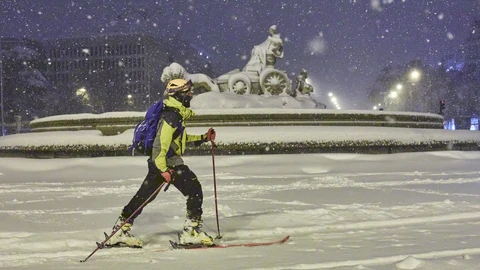 Una persona avanza con esquíes junto a la fuente de Cibeles, cubierta de nieve por la borrasca Filomena, en Madrid.