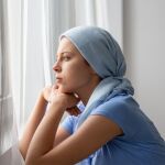 mujer con cáncer mirando por la ventana