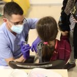 Un trabajador sanitario inyecta la vacuna contra el Covid-19 a un menor