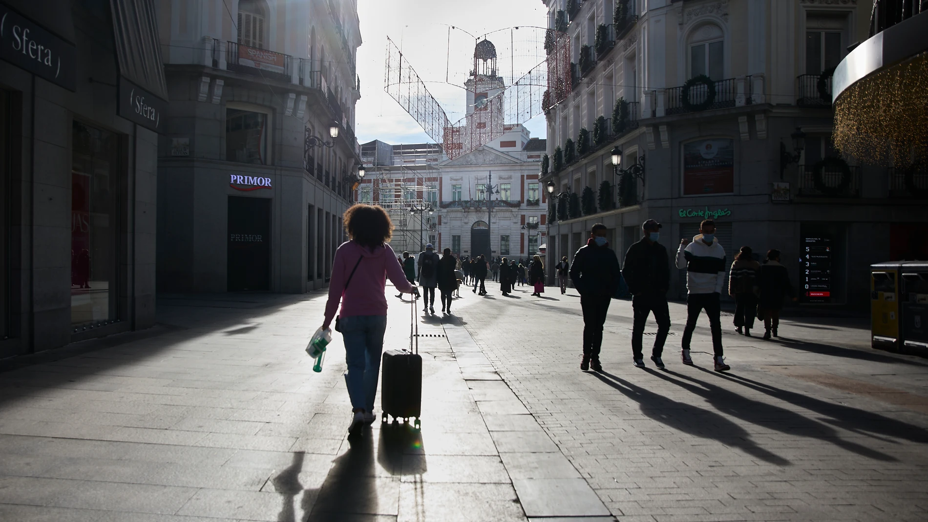 Transeúntes caminan por una vía del centro de Madrid durante el día de Año Nuevo