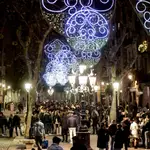 Varias personas celebran la entrada de año nuevo en el paseo de la Barceloneta de Barcelona, justo al inicio del horario del toque de queda a la una de la madrugada