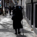 Una mujer de la tercera edad camina por una calle de Madrid