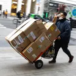 Repartidor de mercancías con un carro lleno de cajas por el centro de Madrid