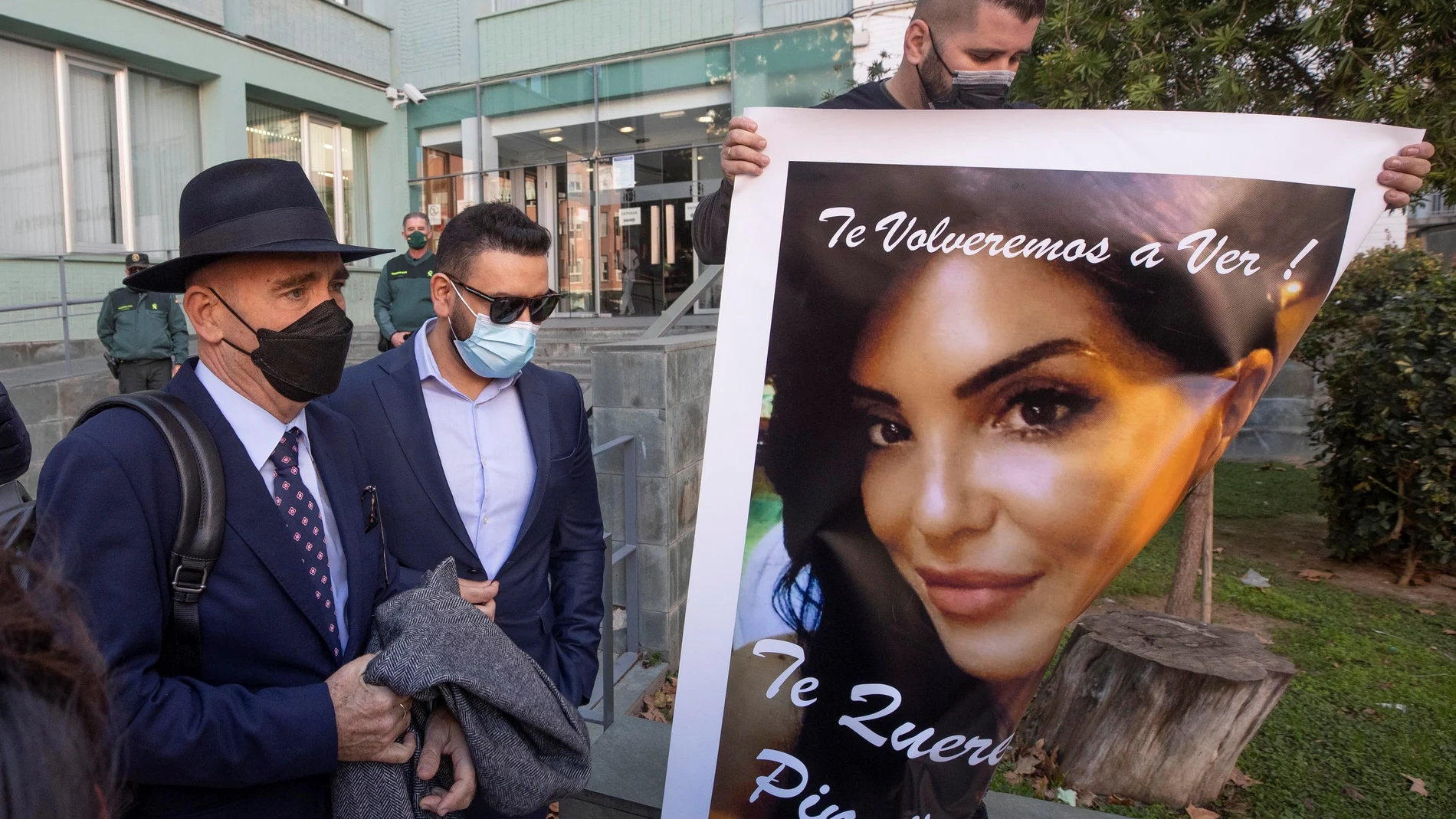 Un familiar (d) de la mujer de Alcantarilla (Murcia) de 39 años que murió un mes después de ser sometida a una lipoescultura en una clínica privada de Cartagena, muestra un retrato de la misma a la salida del cirujano Javier Alejandro Masso (2i) del Palacio de Justicia de Cartagena este miércoles.