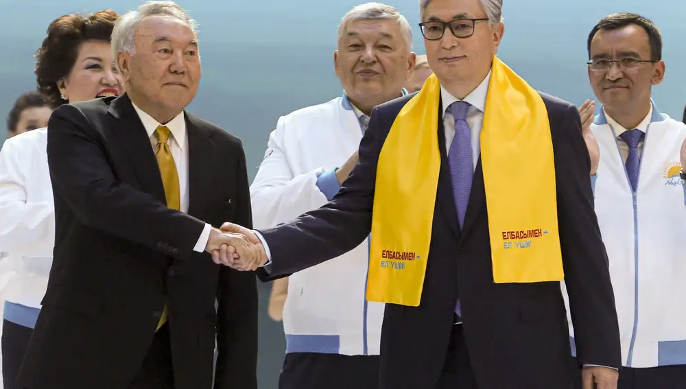 El presidente Kassym-Jomart Tokayev, a la derecha, y el ex presidente kazajo Nursultan Nazarbayev se dan la mano ante sus partidarios en Nur-Sultan, capital de Kazakistán, en 2019