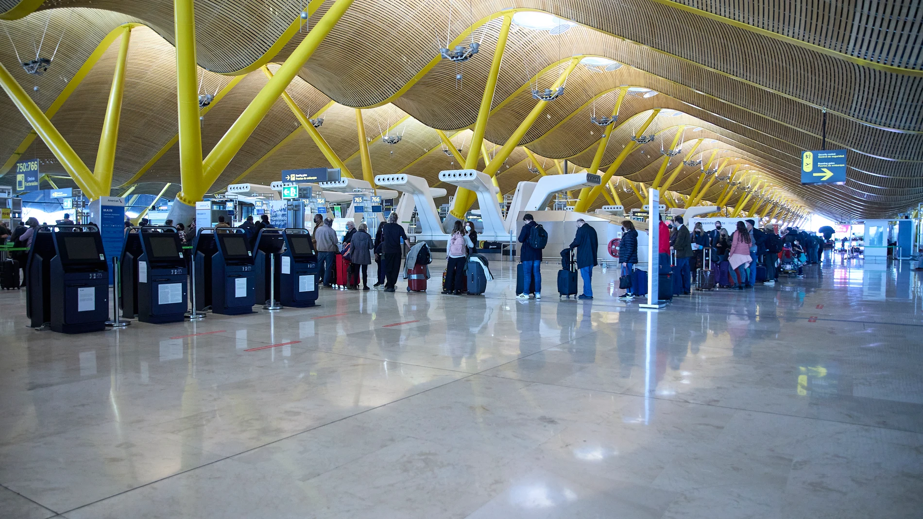 Varias personas hacen cola en el aeropuerto Adolfo Suárez, Madrid-Barajas