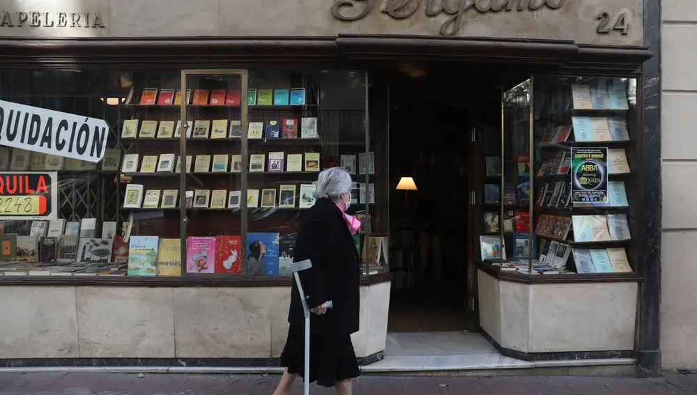 Una mujer delante del escaparate de la librería Pérgamo, el día que echa el cierre definitivo: el 5 de enero