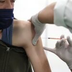 Un trabajador médico recibe su tercera dosis de la vacuna Pfizer COVID-19 en un centro de vacunación en el complejo de Tokio