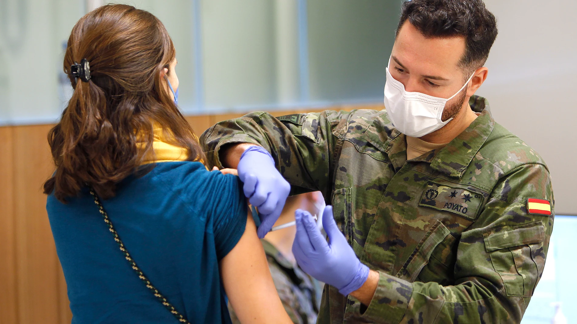Un militar de las Fuerzas Armadas vacuna a una mujer tras incorporarse a los equipos de vacunación del IB-Salud de Baleares, en el espacio Francesc Quetglas, a 7 de enero de 2021, en Palma de Mallorca, Mallorca, Islas Baleares (España).