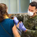 Un militar de las Fuerzas Armadas vacuna a una mujer tras incorporarse a los equipos de vacunación del IB-Salud de Baleares, en el espacio Francesc Quetglas, a 7 de enero de 2021, en Palma de Mallorca, Mallorca, Islas Baleares (España).